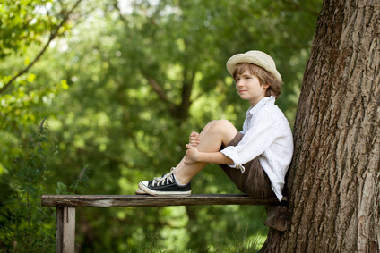 Boy sits on a wooden bench