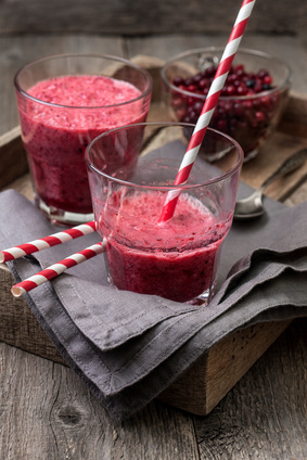 berry smoothie of cowberry, cranberries in a glass on a wooden background